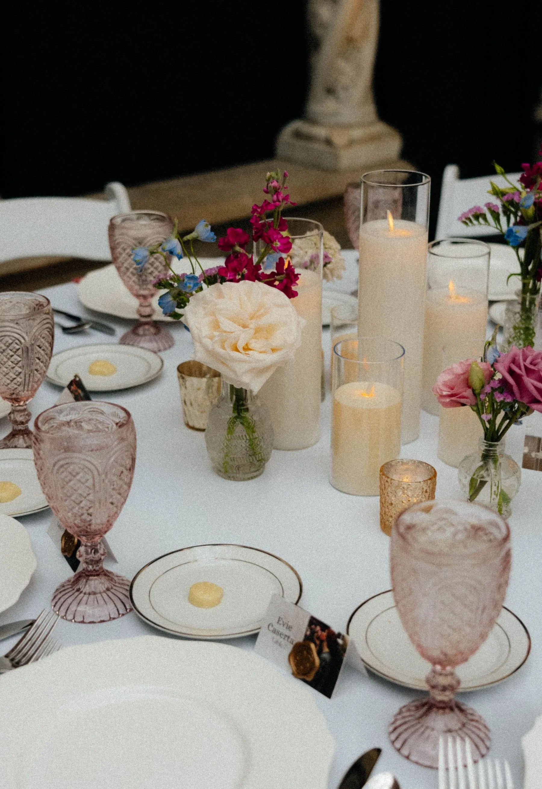 Colourful candlelit tablescape with layered glassware