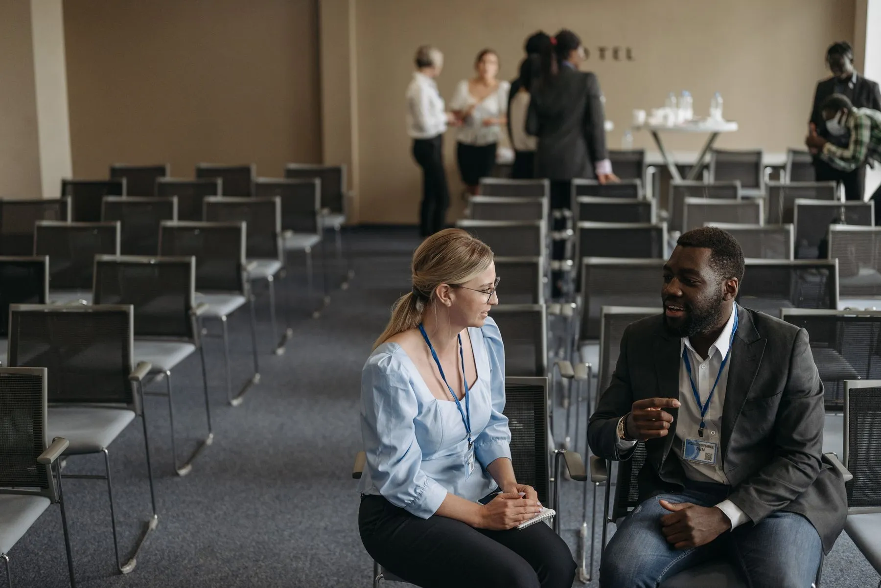 Two professionals speaking during a conference break