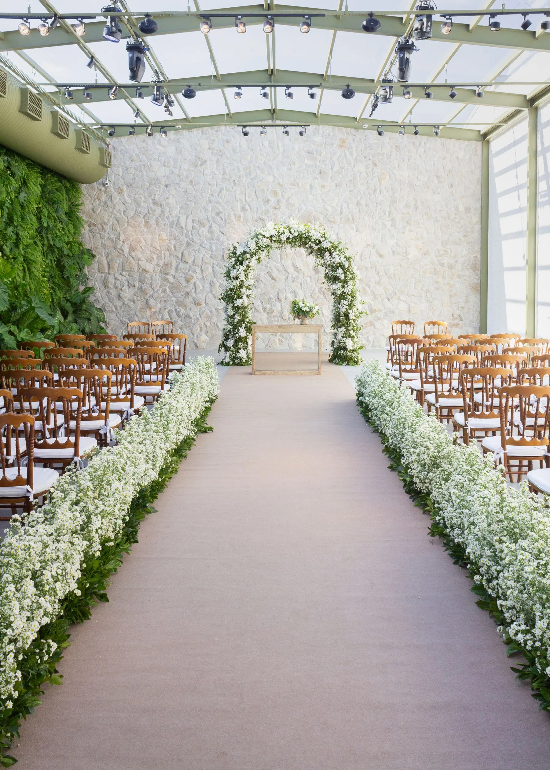 Indoor wedding ceremony arch with floral details