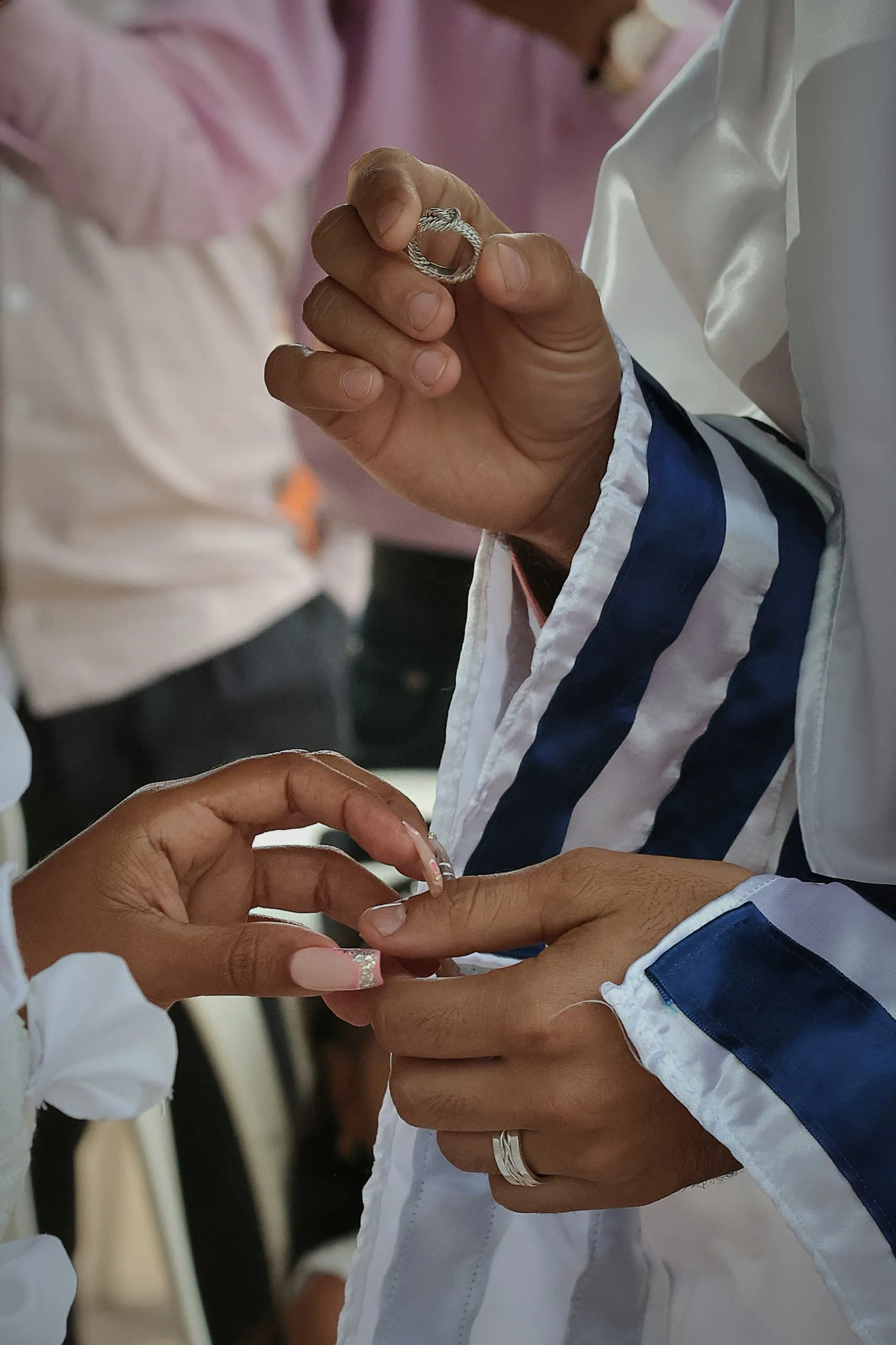 Hands exchanging a ring during a Jewish wedding ceremony