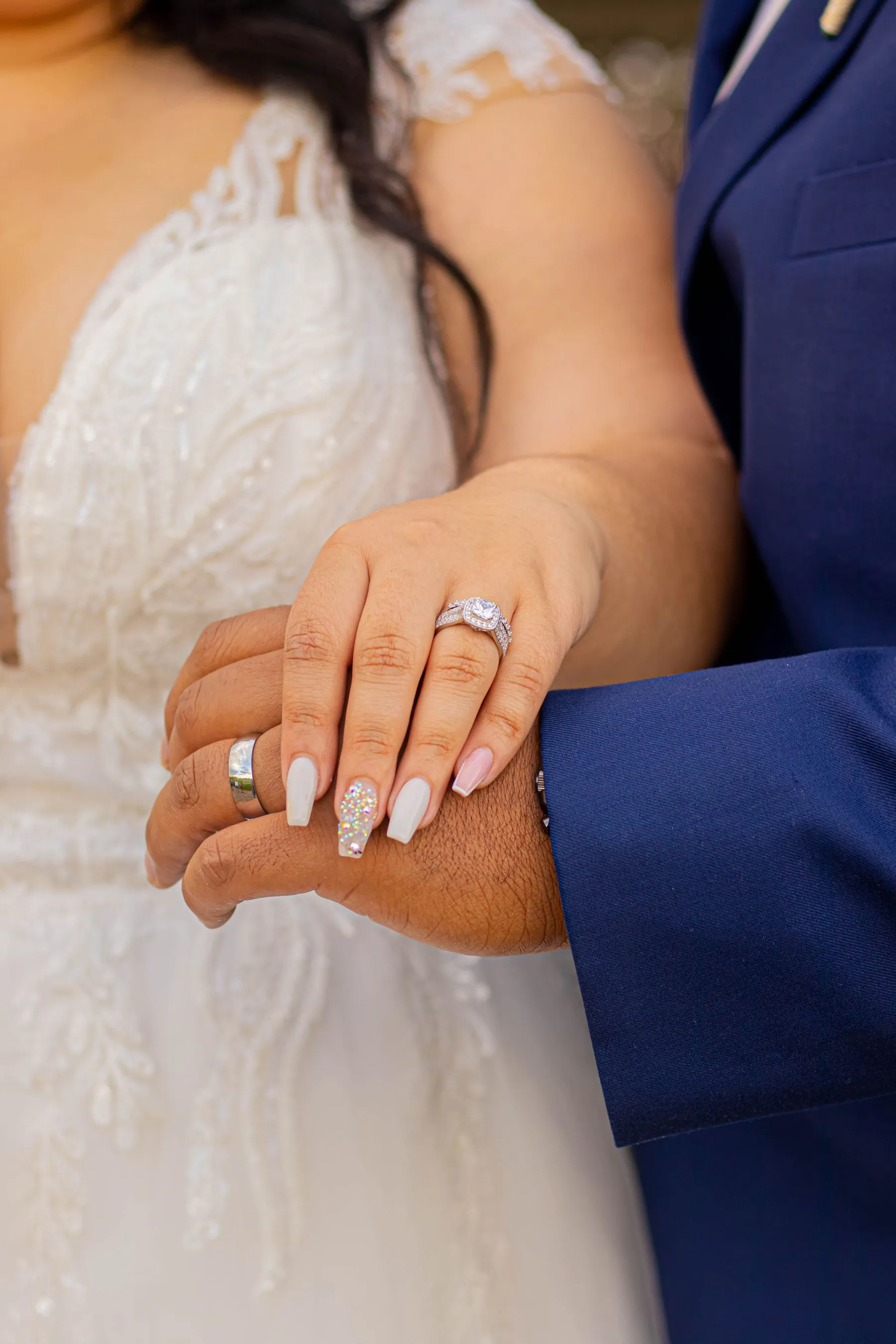 Couple holding hands and showing wedding rings
